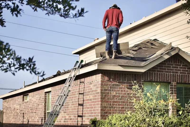 Professional roofer working on a residential roof in Henery Ford